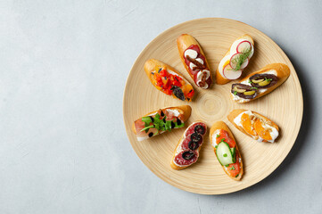 Brushetta, antipasti  or authentic traditional spanish tapas set on wood plate. Variety of  pinchos...