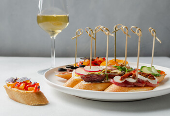 Brushetta, antipasti  or authentic traditional spanish tapas set with wine on the grey background....