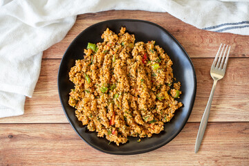 Bulgur salad on wood floor. An appetizer prepared with bulgur and green vegetables. Traditional Mediterranean cuisine delicacies. Local name kisir salatasi. Top view