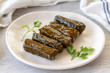 Stuffed leaves with olive oil on a stone background. Traditional Mediterranean cuisine delicacies. Local name zeytinyagli yaprak sarma or dolmadika. close up