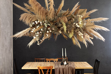Holiday family dinner. Living room with Composition dry decoration plant on wall.Cozy room...