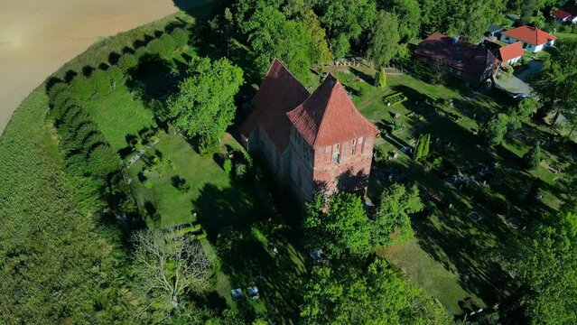 Speed Ramp, fields and akker
Perfect aerial view flight fly forward drone
of red brick village church in hohenkirchen germany at summer day golden hour August 2022. Marnitz 4k Cinematic  from above