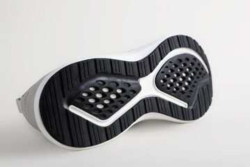 Close-up black rubber sole one modern new sneaker, sports shoes on a light background