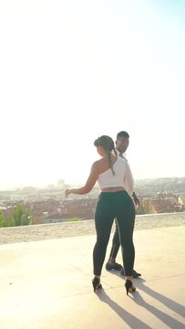 Full body dancers doing bachata moves in the street. Attractive African American man and Caucasian woman doing dance moves outdoors. Slow motion video. 