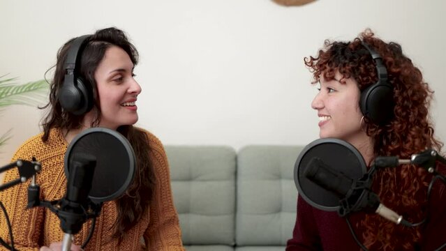 Latin Female host recording radio podcast interview with guest at home studio