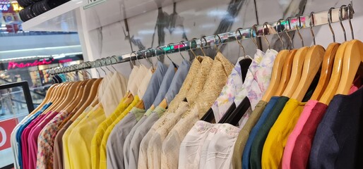 close up of colorful female clothes in boutique hanging on hanger