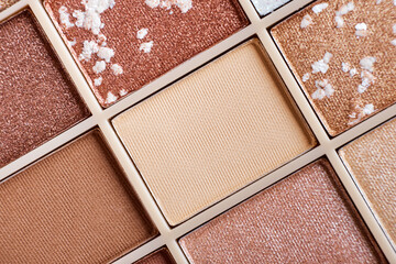 Fototapeta premium Eyeshadow colorful shades palette in beige tones close-up. Beauty abstract background