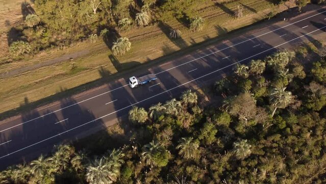 aerial footage of an empty tow truck driving on a rural route at sunset in Uruguay , South America