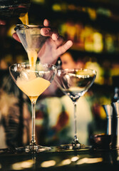 man hand bartender pouring cocktail in glass on the bar counter