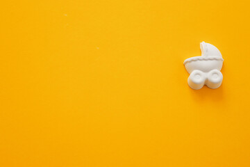 Fototapeta na wymiar A plaster figure of a baby carriage on a colored background