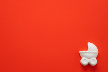 A plaster figure of a baby carriage on a colored background