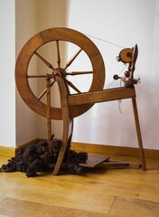 Spinning Wheel, Old Fashioned Wool. Pictured in a bright craft room. Vintage tailoring equipment...