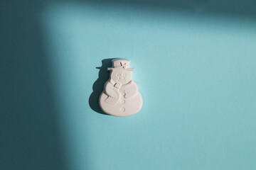 Plaster figure of a snowman on a colored background