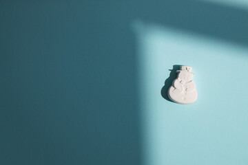 Plaster figure of a snowman on a colored background