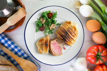 Wellington steak prepared with pork and salad on the side.