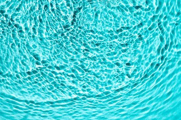 Sunny blue water background texture, top view.