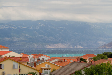 Fototapeta na wymiar View over the roofs of Baska, island of Krk, Croatia with Mediterranean Sea and mountains