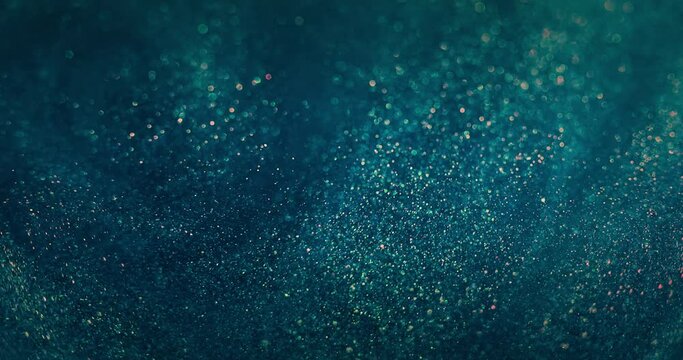 Bokeh glitter swirl. Particles background. Blur circles motion. Defocused blue orange color sparkling bubbles whirl on dark abstract vertical texture. Shot on RED Cinema camera.