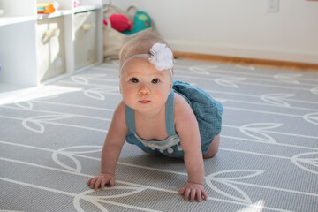 Cute little caucasian baby girl learning how to crawl 