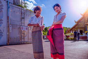 Women tourist readjust their dress properly and correctly before entering Thai temple where correct...
