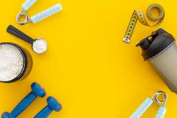 Sport bottle and jar of powder whey protein and dumbbells. Fitness and gym diet