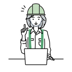 デスクで座ってPCを開いて何かひらめいた工事現場の女性