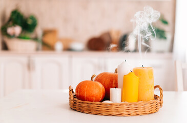 Pumpkins and extinguished candles with smoke on a wooden table against the background of the...