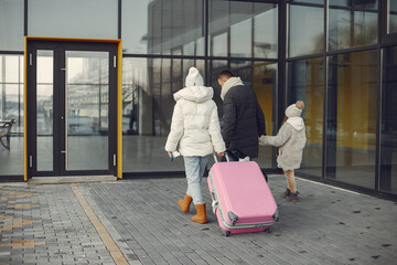 Mother, father and daughter with luggage going to airport terminal - obrazy, fototapety, plakaty