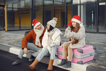 Family sitting outdoors on a luggage and waiting for travel