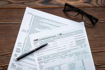 Fototapeta premium Businessman table with US tax form and pen. Culculating and payment of taxes