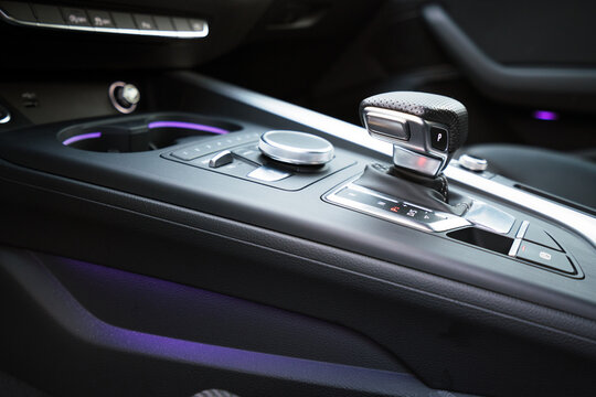 gear shifter knob inside a luxury car with purple neon lights. car interior and high end photography.