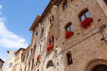 Street view grass wall windows house exterior San Gimignano Toscany Italia 
