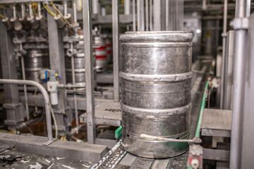 Brewery, bottling beer on aluminum kegs on conveyor lines. Industrial work, automated modern food and beverage production.