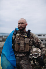 A military man holds the flag of Ukraine. Portrait of the defender of Ukraine.