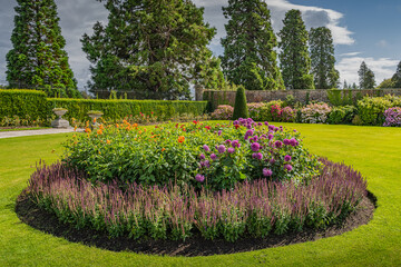Circular flowerbed in beautiful Powerscourt garden with hedges, decorative trees, fountains and...