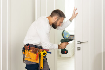 High Angle View Of Male Carpenter With Screwdriver Fixing Door Lock
