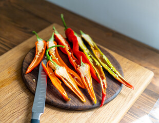 cut pods of red hot pepper on a wooden board