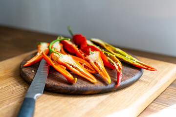 cut pods of red hot pepper on a wooden board