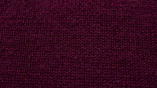 Dark red knitted fabric texture. Closeup detailed sweater fabric background. Soft woolen textile pattern for winter fashion background