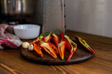 cut pods of red hot pepper on a wooden board