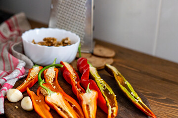 cut pods of red hot pepper on a wooden board