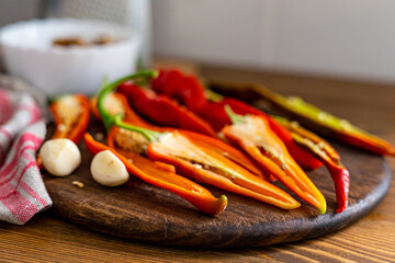 cut pods of red hot pepper on a wooden board