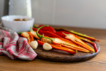 cut pods of red hot pepper on a wooden board