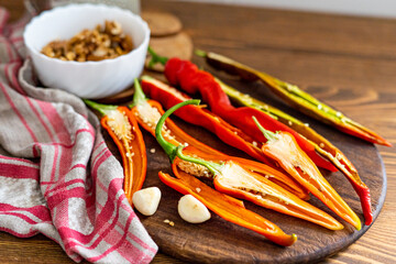 cut pods of red hot pepper on a wooden board