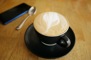 a cup of late coffee with flower shape design on top at cafe 
