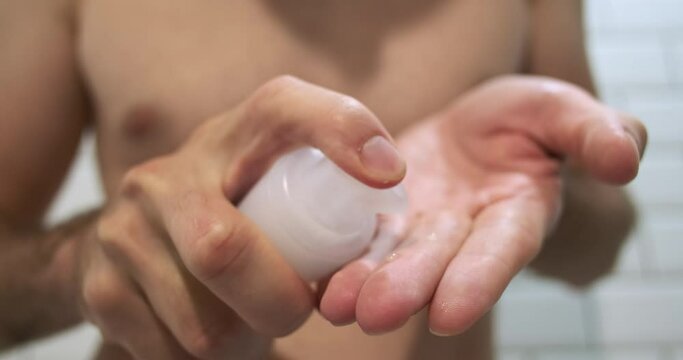 Male hands squeeze the intimate gel onto their fingers. Close-up, using sex lubricant.