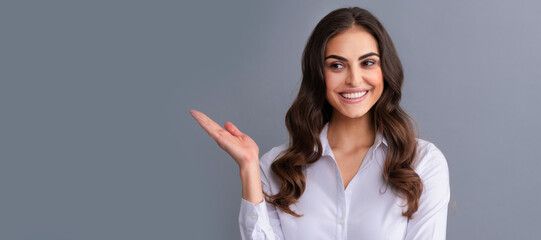 Happy professional woman manager show open hand for copy space grey background, presenting product....