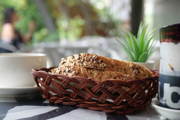 Obraz premium whole grain baked bread and cup of tea for morning breakfast 