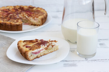 Classic American pie with sour cream and apples on a white wooden background Milk in a glass