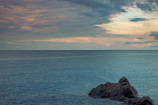 Calm sea with cloudy sky at sunset. Panorama of the Mediterranean sea in Liguria